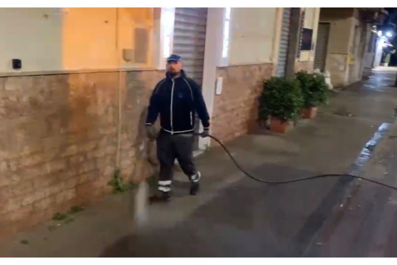 foto di addetto al lavaggio strade